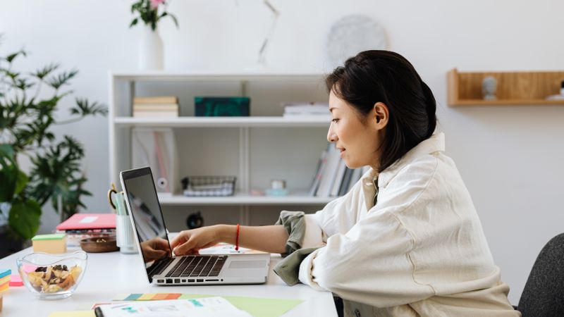 Personne en reconversion travaillant sur son ordinateur à domicile